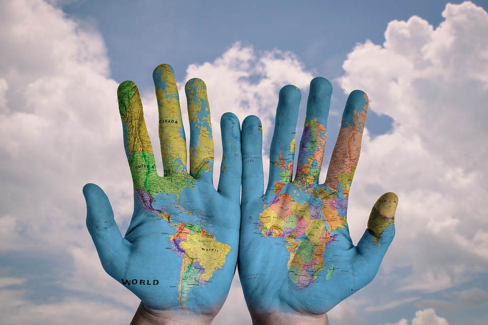 Hands showing a map of the world